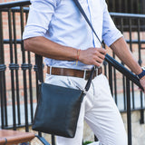 Model carrying Lucca Mens Leather Shoulder Bag from Rydal in 'Black'.