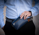 Man Carrying Leather Wrist Bag from Rydal in 'Royal Blue'.